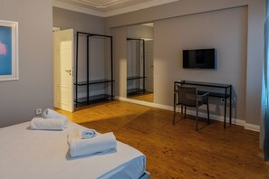 Une chambre d’hôtel équipée d’un lit, d’un bureau, d’une chaise, d’une télévision et d’un miroir.