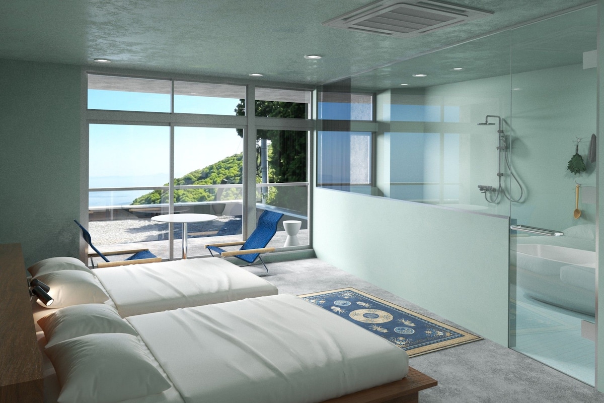 A modern hotel room with a large bed, a balcony with a view, and a separate shower area.