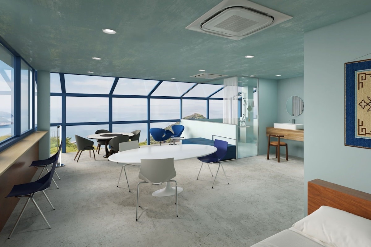 A modern interior with a large window, a round table, and blue chairs.