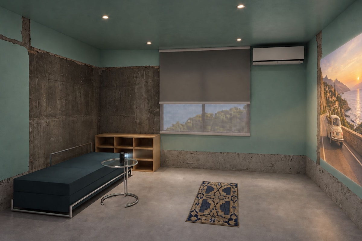 A room with a bed, a small table, a window with a view, and a wall-mounted air conditioner.