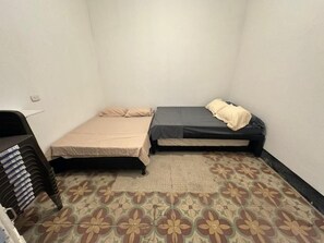 A small, single-room accommodation with a bed, a chair, and a stack of books. - Espectacular Casa con Piscina Privada en el Centro de Girardot (Girardot)