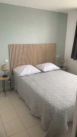 A bedroom with a bed, two bedside tables, and a headboard. - Marina / fully equipped house with a pool, Wi-Fi, and a view of the canal (Le Barcarès)