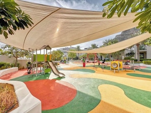 A playground with a slide, swings, and a climbing structure. - Bloomfields 2BR + Maid Address Residences Fujairah (Al Aqah)