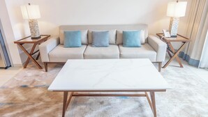 A modern living room with a sofa, two side tables, a coffee table, and a lamp on each side. - Bloomfields 2BR with maid Address Resid (Al Aqah)