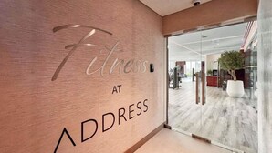 A modern interior with a sign reading 'Fitness at ADDRESS' on a textured wall. - Bloomfields 2BR with maid Address Resid (Al Aqah)