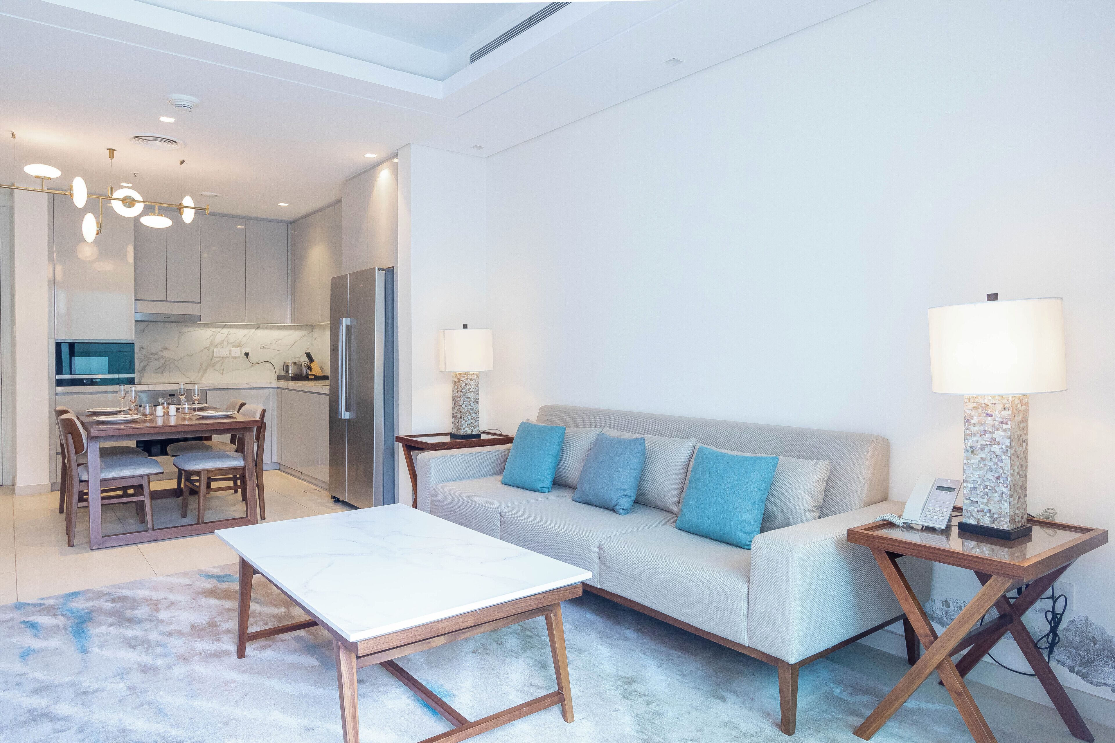 Un salon moderne avec un canapé, une table basse et des lampes.
