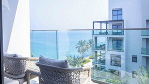 A balcony with wicker furniture and a view of the sea. - Bloomfields 2BR with maid Address Resid (Al Aqah)