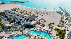 Un complejo turístico con varias construcciones, piscina y playa.