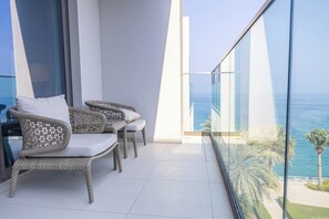 A balcony with wicker furniture and a view of the sea. - Bloomfields 2BR with maid Address Resid (Al Aqah)