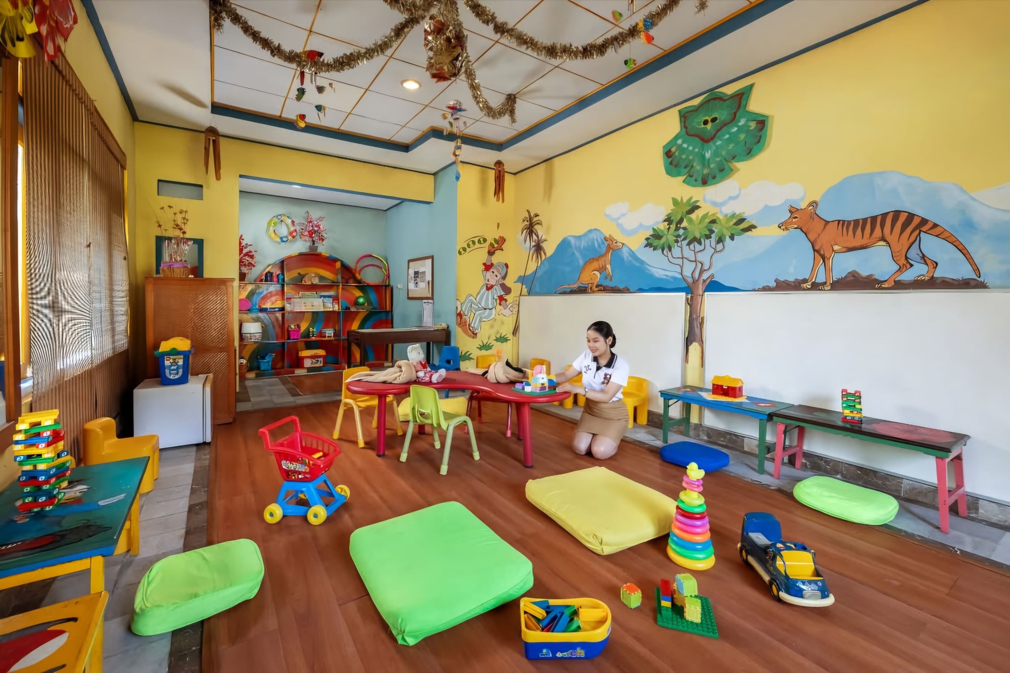 Uma sala de brinquedos infantis com mobiliário colorido, brinquedos e materiais educativos.