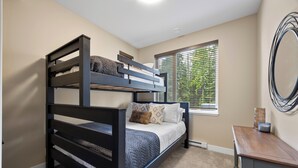 A bunk bed with a window, a small table, and a mirror on the wall. - Cozy Alpine Condo w/Hot Tub! (Sun Peaks)