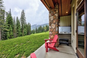 Un muro exterior de piedra, una silla roja y un jacuzzi.