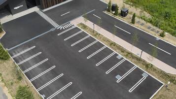 Een parkeerplaats met aangegeven parkeerplaatsen en een voetpad.