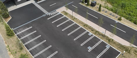 A parking lot with marked parking spaces and a pedestrian pathway.