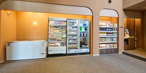 A hotel lobby with a self-service beverage station, a cashier area, and a seating area.