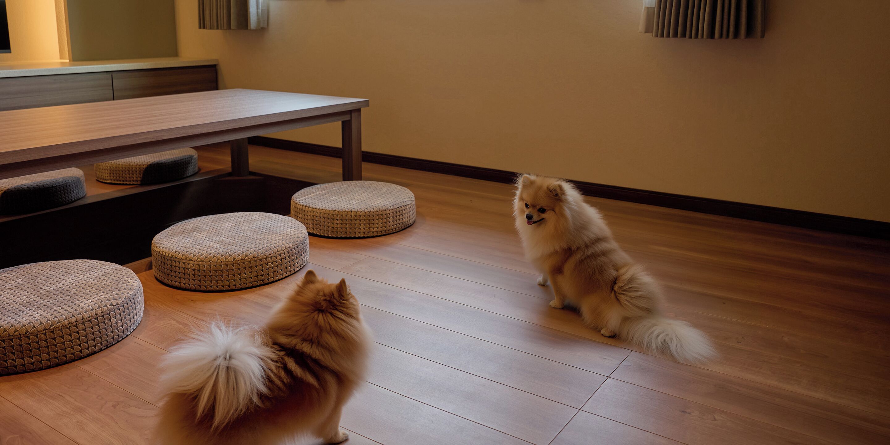 A room with a wooden floor, a table, and three round ottomans.