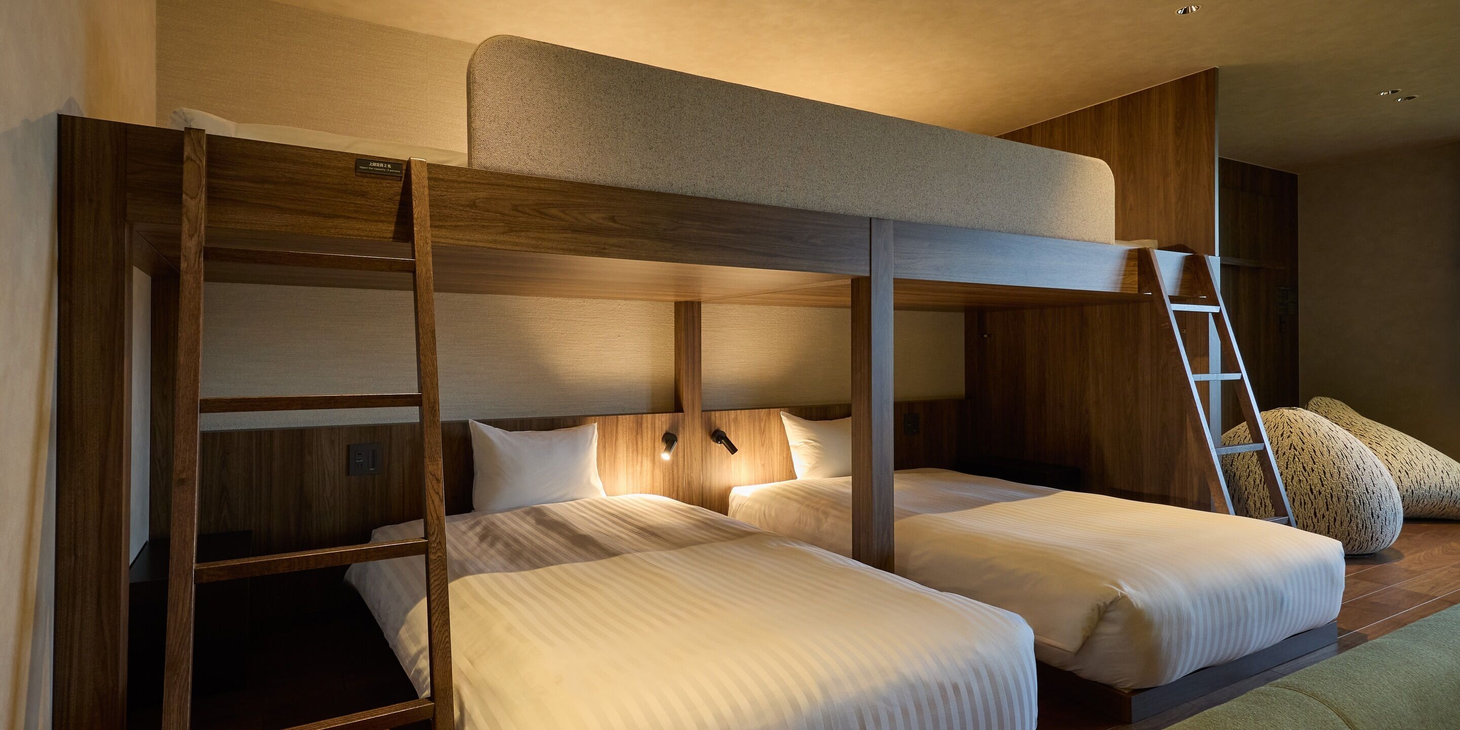 Une chambre avec un lit superposé, comprenant deux lits, une échelle et une tête de lit.