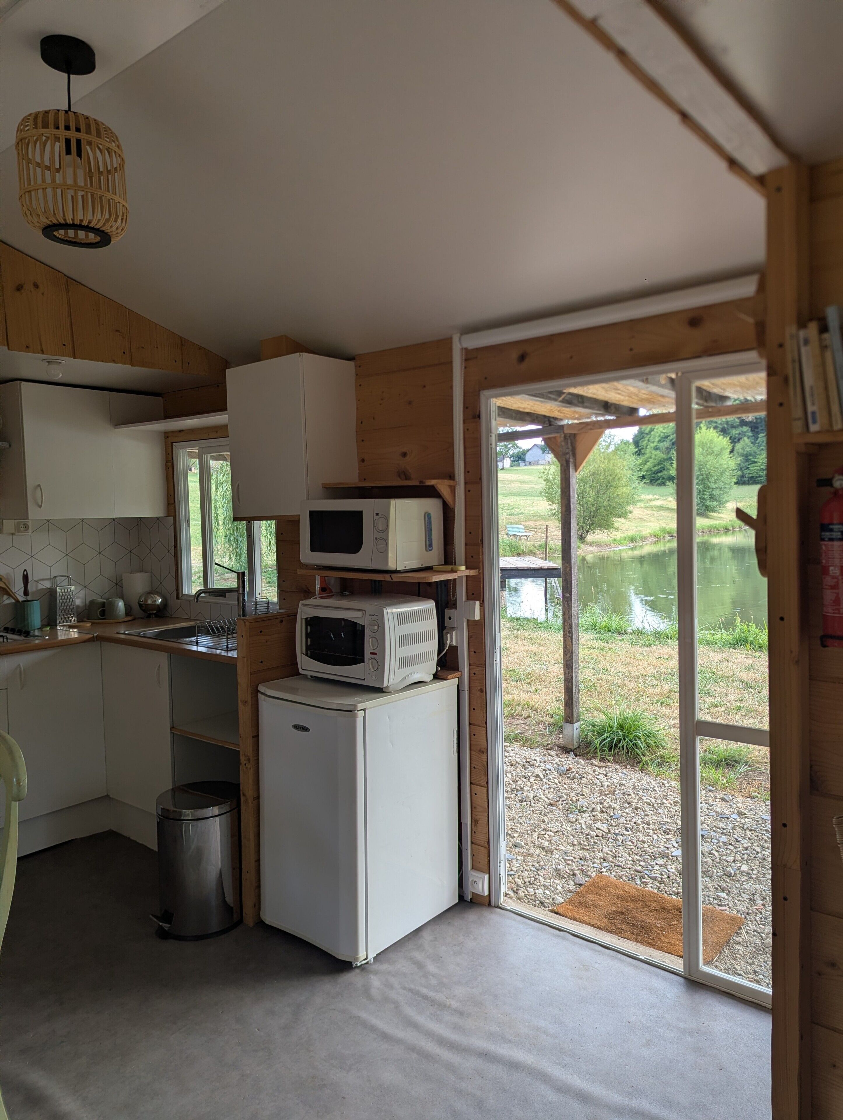 A compact kitchen with wooden cabinets, a microwave, and a refrigerator.