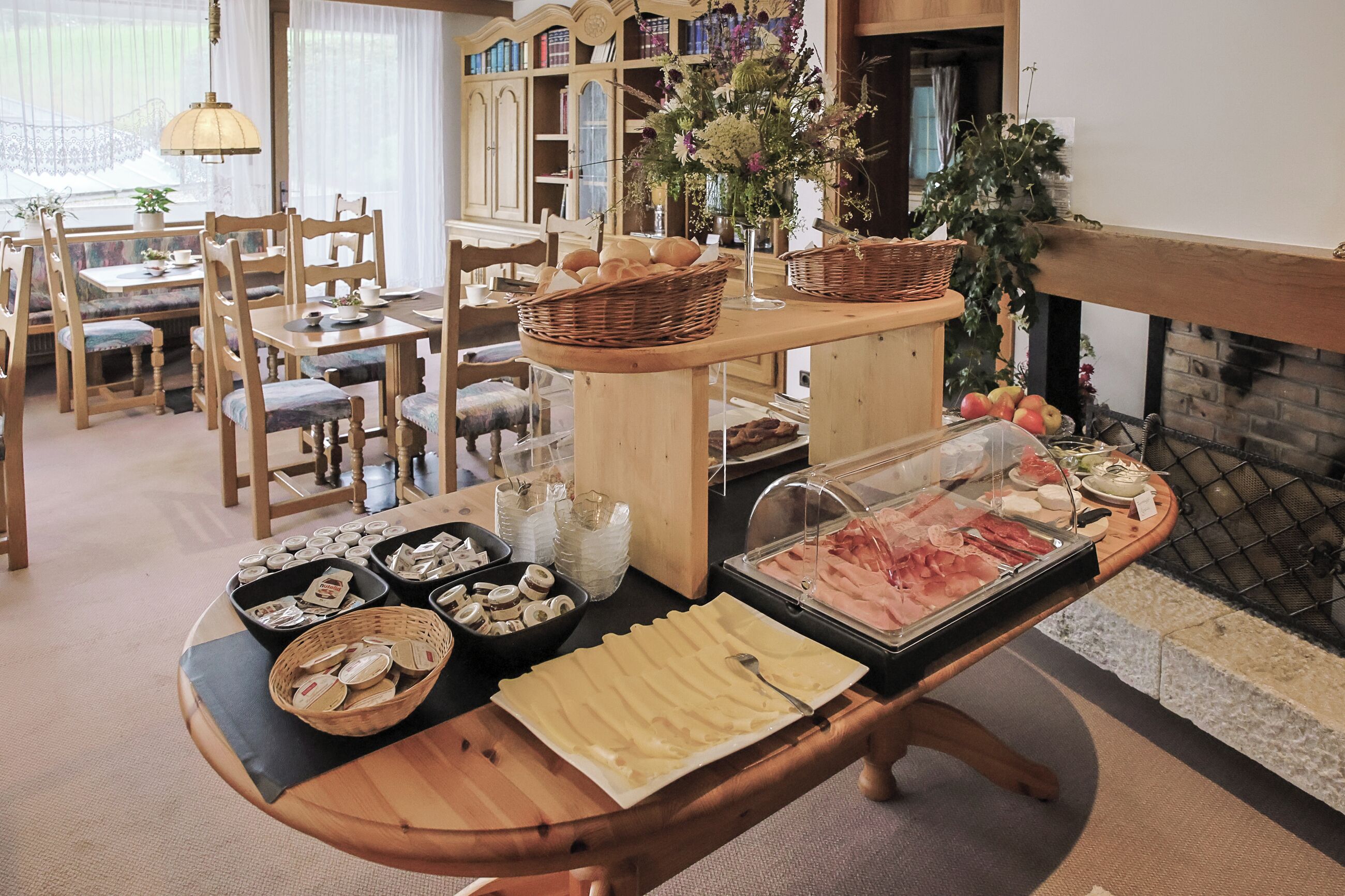 Een buffetopstelling met verschillende gerechten en een boekenselectie op de achtergrond.
