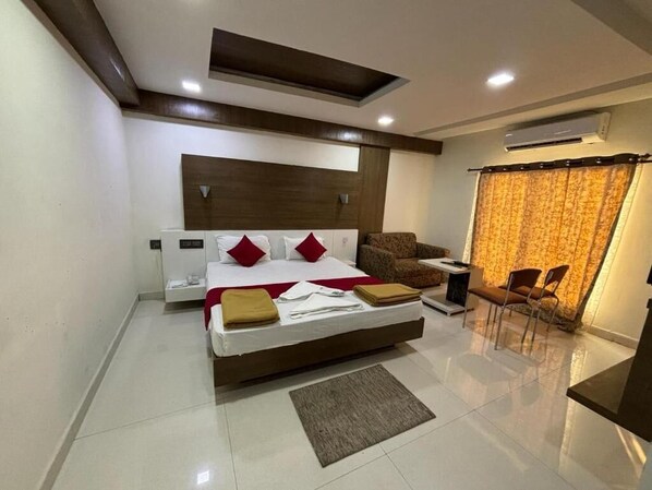 A modern bedroom with a bed, bedside tables, a sofa, and a window with curtains.