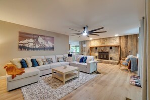 A modern living room with a sectional sofa, a coffee table, a fireplace, and a ceiling fan. - Fire Pit & Lake Access! Crossville Group Escape (Crossville)
