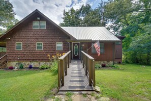 A rustic wooden building with a metal roof, a wooden porch, and a flag. - Fire Pit & Lake Access! Crossville Group Escape (Crossville)