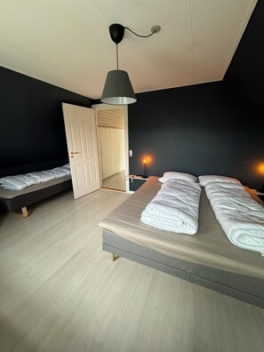 Ein Schlafzimmer mit Bett, Nachttisch, Lampe und Kleiderschrank.