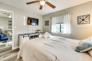 A bedroom with a bed, a desk, a TV, and a ceiling fan. - Unwind Poolside, Walk to Beach! Tennis, Pickleball (Hilton Head Island)