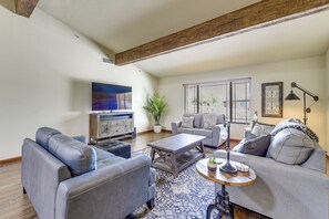 Ein Wohnzimmer mit einer Couch, einem Couchtisch und einem Fernseher.