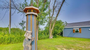A wooden structure with a lantern on top, surrounded by grass and trees. - Bayfront Home! Dock, Deck, Hot Tub, & Fire Pit (Oconto)
