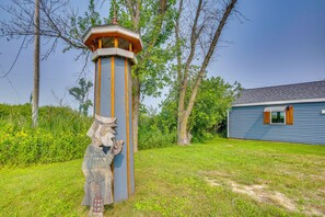 A wooden structure with a lantern on top, surrounded by grass and trees. - Bayfront Home! Dock, Deck, Hot Tub, & Fire Pit (Oconto)