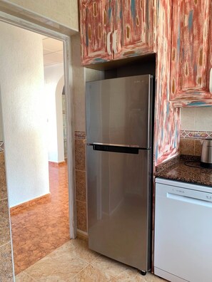 A kitchen with a stainless steel refrigerator, a dishwasher, and a tiled backsplash. - Casa Czuberny – Holiday Retreat (VC)