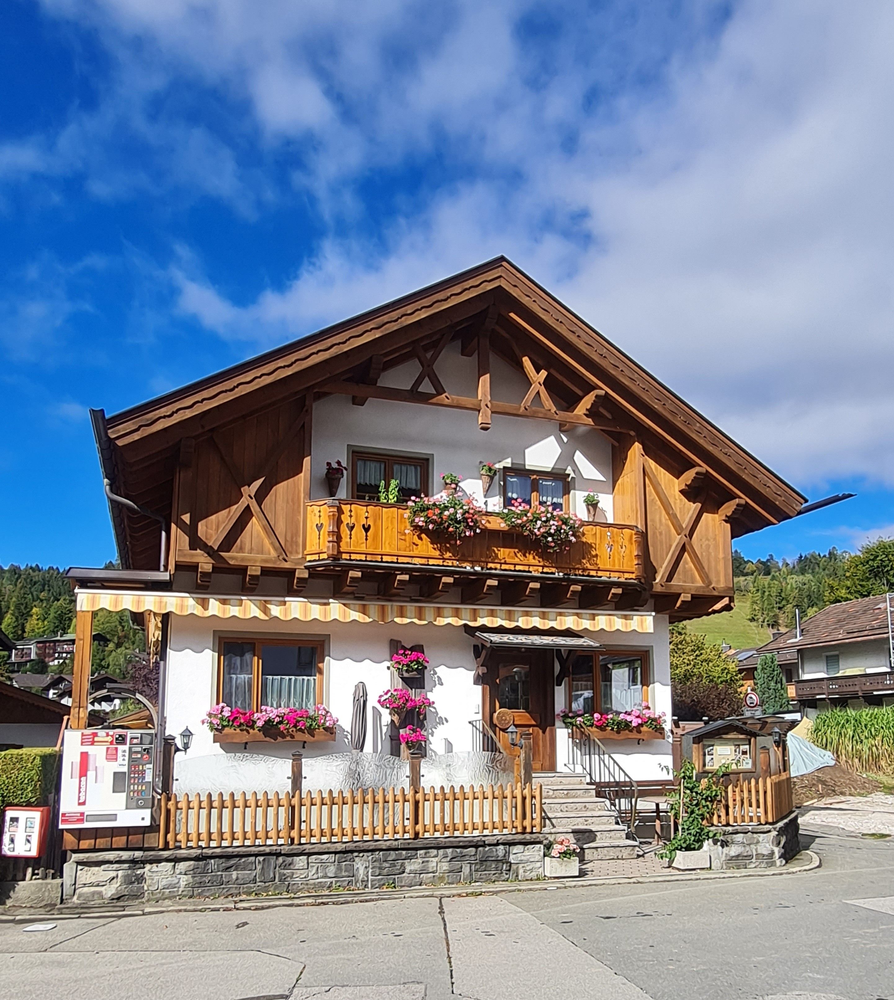 Un bâtiment à deux étages doté d’un balcon en bois, de fondations en pierre et surplombant un ciel dégagé.