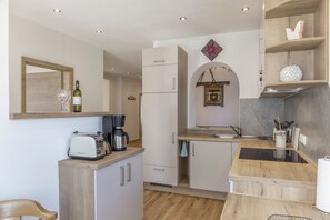 A compact kitchen with a toaster, coffee maker, and a hanging light fixture. - Apartment "Karwendel" with Mountain View, Private Terrace and Wi-Fi (Mittenwald)