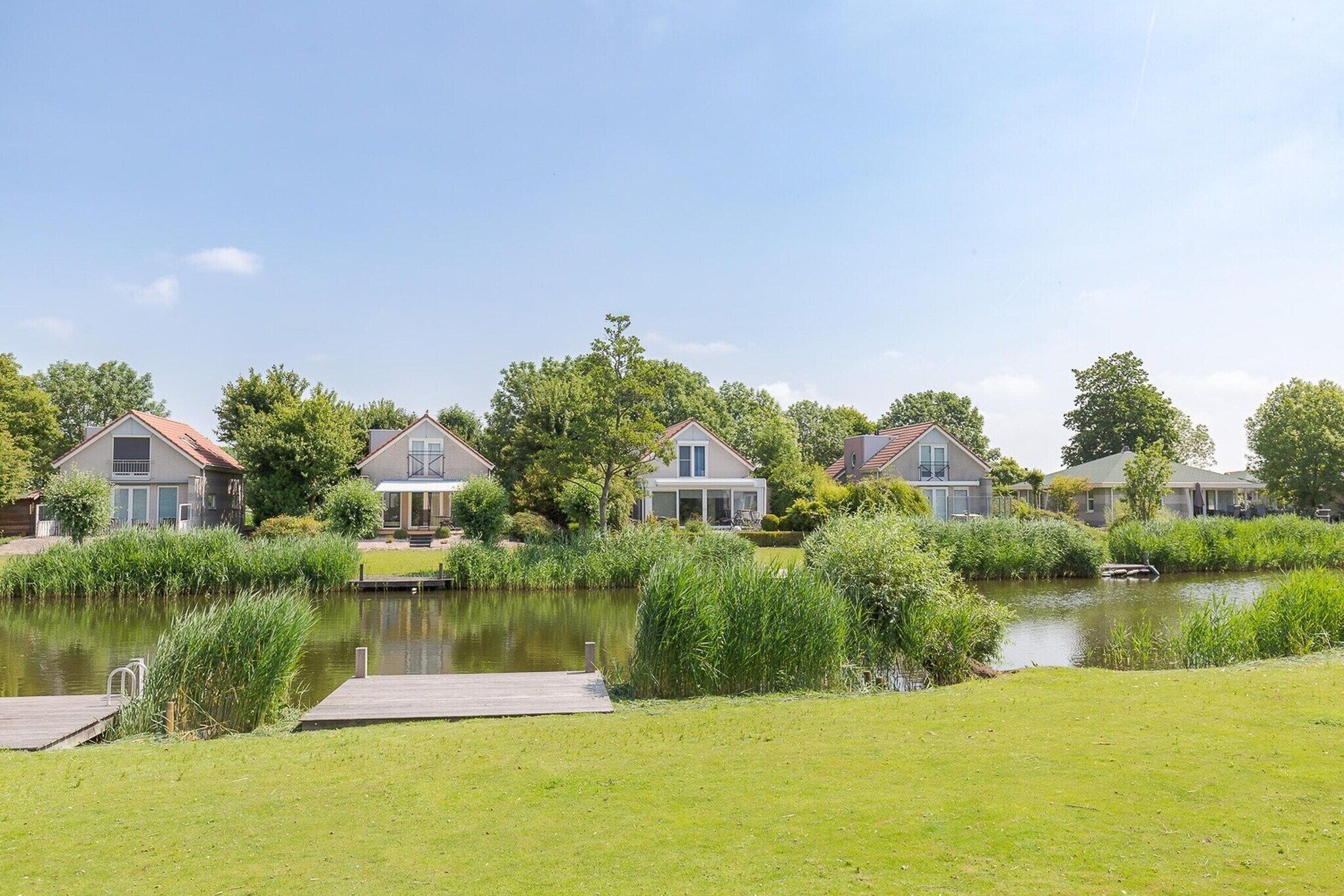 A row of houses with a pond in the foreground.