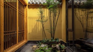 A traditional Japanese-style room with a tatami mat floor, a shoji screen door, and a small indoor garden with rocks and plants. - Xuzhu Avatar Mountain Hideaway (Zhangjiajie)