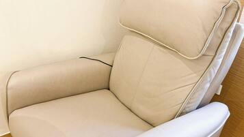 A beige leather chair with a high backrest and armrests.