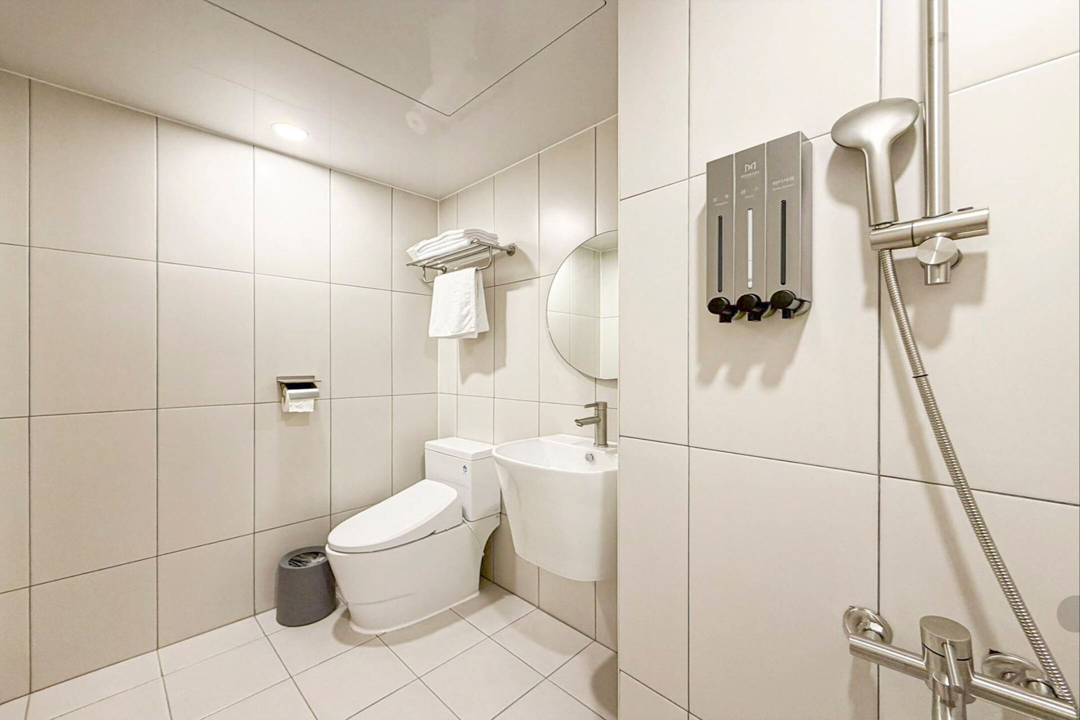 A modern bathroom with a toilet, sink, and shower.