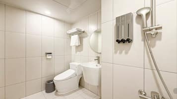 A modern bathroom with a toilet, sink, and shower.
