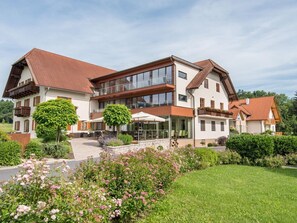 Ein großes, zweistöckiges Gebäude im modernen Stil mit großen Fenstern und einer weitläufigen Außenpatio.