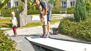 A person standing on a concrete platform with a child and an adult nearby. - Lakeview Apartment with Dual Balconies (Makkum)