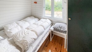 A single bed with white bedding in a room with wooden flooring and a window with a view of greenery. - 3 bedroom nice home in Skjern (Skjern)