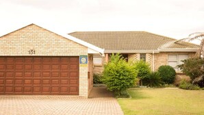 Une propriété résidentielle dotée d’un garage en briques et d’un toit recouvert de tuiles.