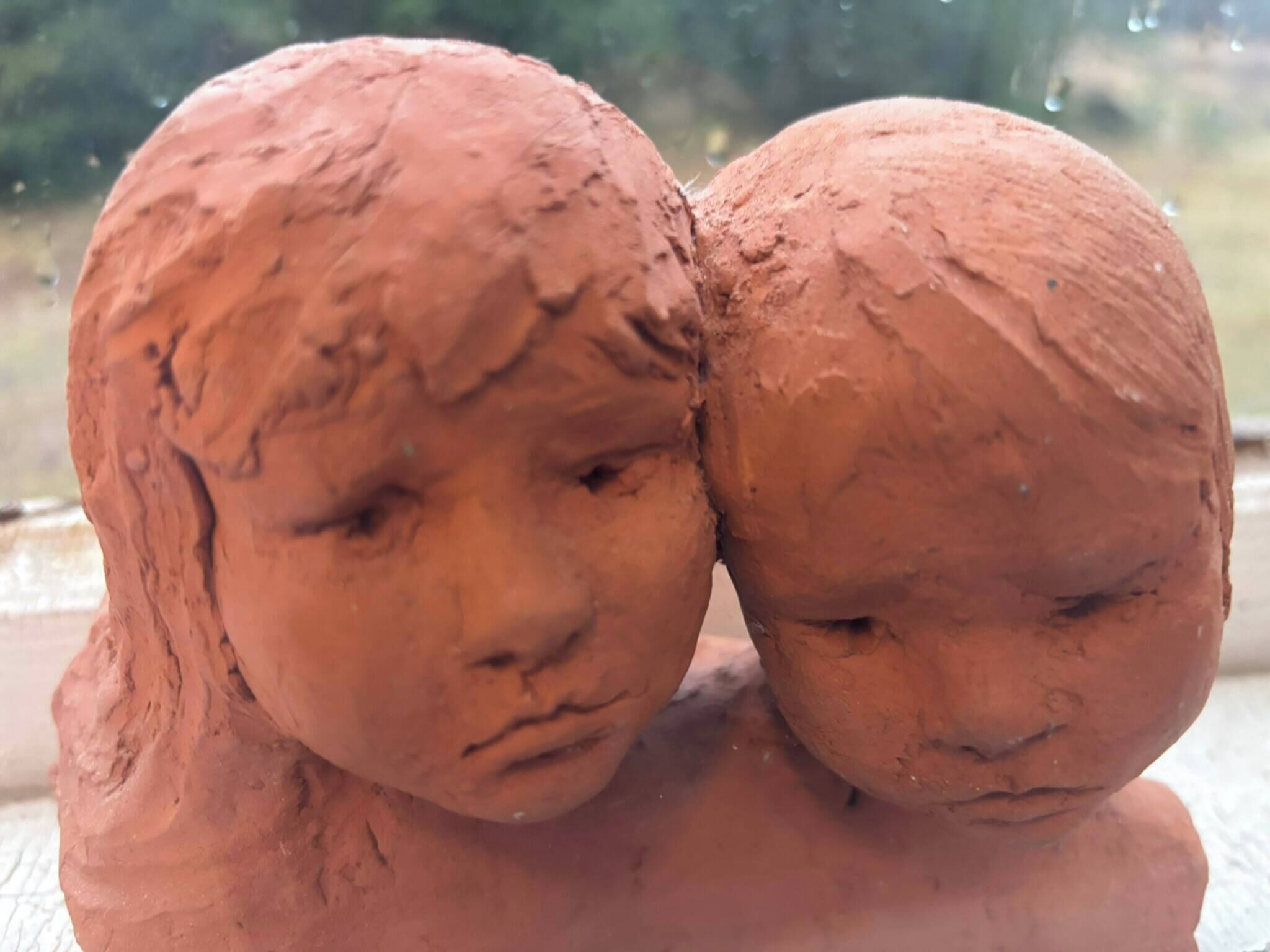 A sculpture of two figures with a blurred background.