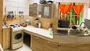 A kitchen with a stove, sink, and a washing machine. - Nomad Nest near Guatapé Jacuzzi Turkish WiFi-full (El Peñol)