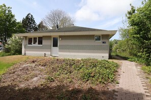 A single-story building with a flat roof, a door, and a small window. - Comfortable Bungalow Stay by the Water (Makkum)