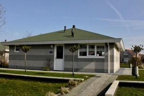 A single-story house with a green roof, a front door, and two windows. - Luxury 3BR Waterfront Villa (Makkum)