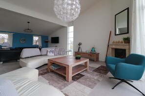 Ein modernes Wohnzimmer mit einer Couch, einem Couchtisch und einem blauen Sessel.