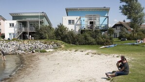 A coastal property with modern buildings, a sandy beach, and a rocky shoreline. - Beach Villa with Sauna for 8 Guests (Makkum)