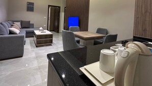 Ein modernes Wohnzimmer mit einer Couch, einem Couchtisch und einem Essbereich mit Stühlen und einem Tisch.